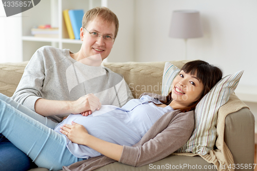 Image of happy pregnant wife with husband at home