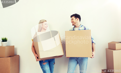 Image of smiling couple with big boxes moving to new home