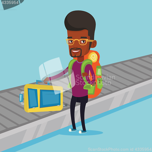 Image of Man picking up suitcase on luggage conveyor belt