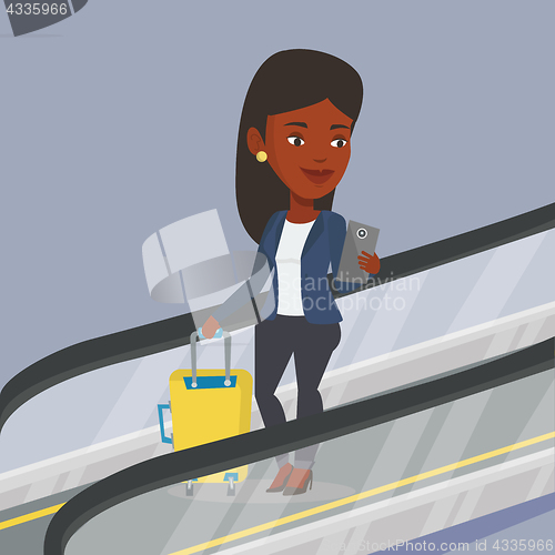 Image of Woman using smartphone on escalator in airport.