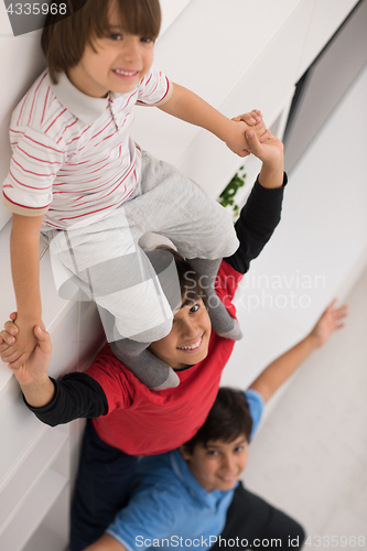 Image of young boys posing line up piggyback top view