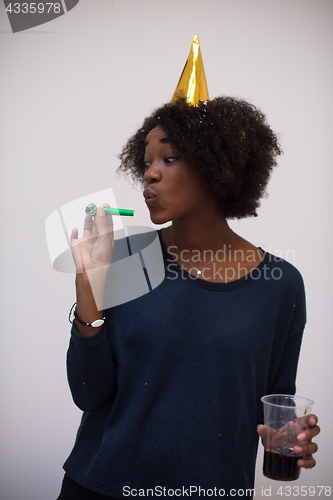 Image of black woman in party hat blowing in whistle