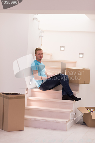 Image of young man sitting in stairway at home