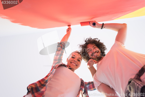 Image of couple painting interior wall