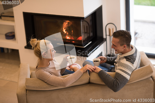 Image of Young couple  in front of fireplace