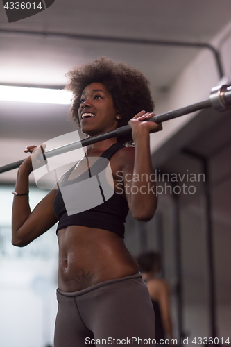 Image of black woman lifting empty bar