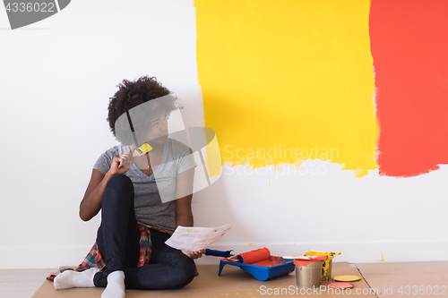 Image of back female painter sitting on floor