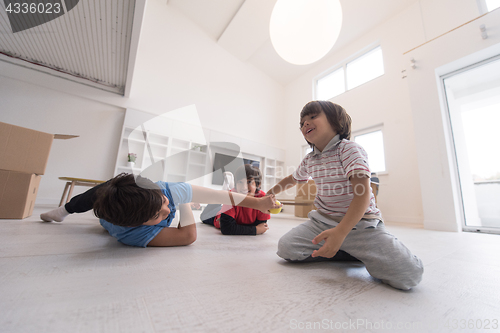 Image of boys having fun with an apple on the floor