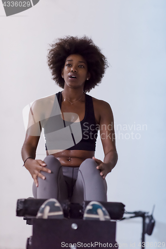 Image of black woman doing sit ups at the gym