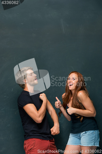 Image of Beautiful woman impressed by the muscles of a bodybuilder, strong man showing off his muscles