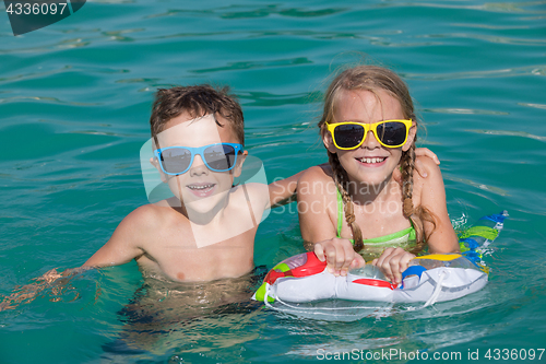 Image of Two happy children playing on the swimming pool at the day time.