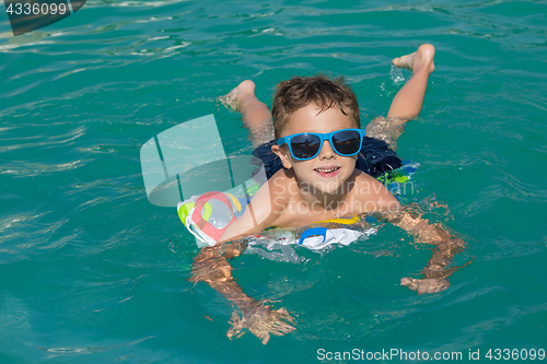 Image of happy child playing on the swimming pool at the day time.