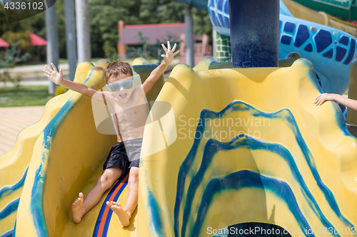 Image of happy child playing on the swimming pool at the day time.