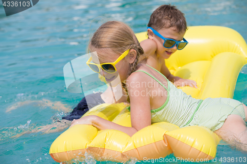 Image of Two happy children playing on the swimming pool at the day time.