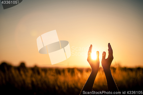 Image of silhouette of female hands during sunset.