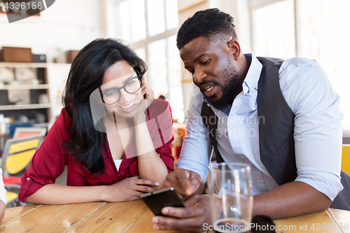 Image of happy man and woman with smartphones at bar