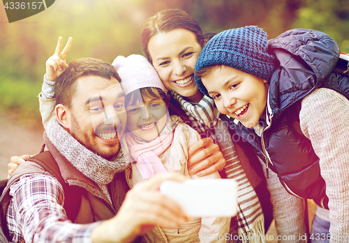 Image of family taking selfie with smartphone in woods
