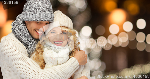 Image of happy couple hugging over christmas lights