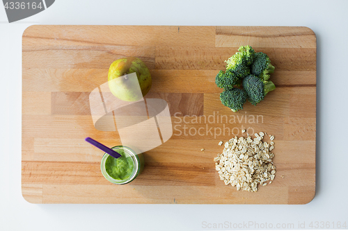 Image of jar with puree or baby food on wooden board