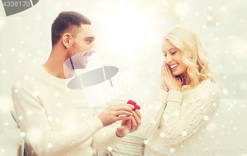 Image of man giving woman engagement ring for christmas