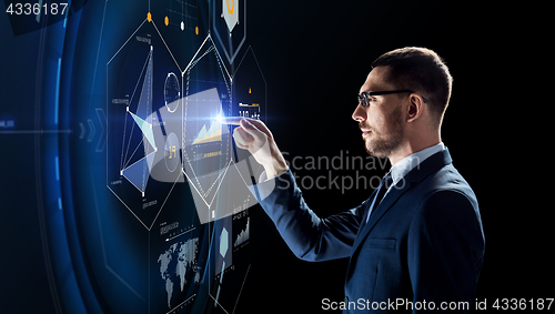 Image of businessman working with charts on virtual screen