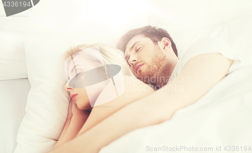 Image of happy couple sleeping in bed at home