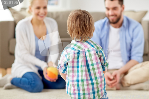 Image of happy family playing with ball at home