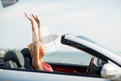 Image of happy young woman in convertible car