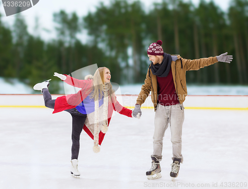 Image of happy couple holding hands on skating rink