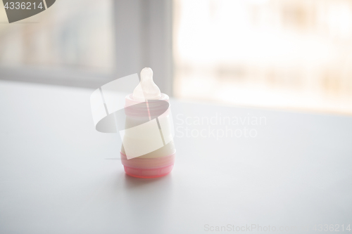 Image of infant milk formula in baby bottle on table