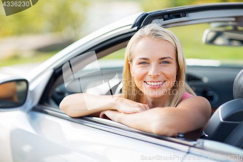 Image of happy young woman in convertible car