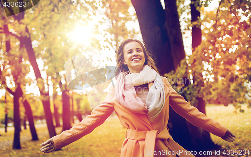 Image of beautiful happy young woman walking in autumn park