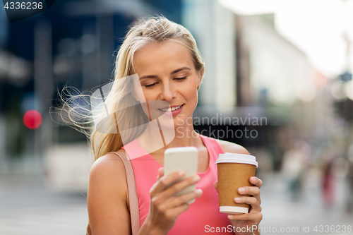 Image of woman with coffee and smartphone in city