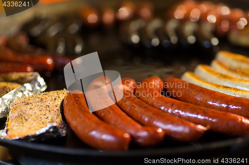 Image of sausages and salmon frying in stir fry pan