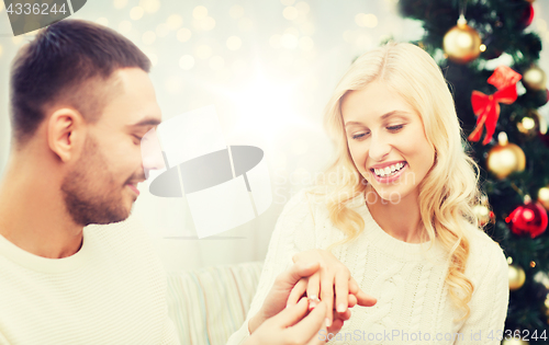 Image of man giving woman engagement ring for christmas