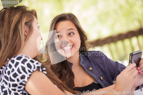 Image of Expressive Young Adult Girlfriends Using Their Smart Cell Phone 