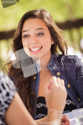 Image of Expressive Young Adult Woman Having Drinks and Talking with Her 