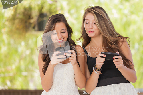 Image of Two Expressive Mixed Race Girlfriends Using Their Smart Cell Pho