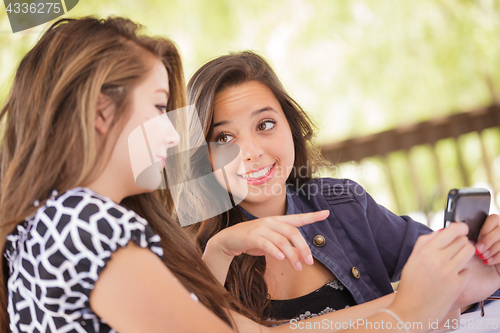 Image of Expressive Young Adult Girlfriends Using Their Smart Cell Phone 