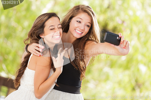 Image of Two Attractive Mixed Race Girlfriends Using Their Smart Cell Pho