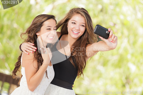 Image of Two Attractive Mixed Race Girlfriends Using Their Smart Cell Pho