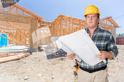 Image of Male Contractor With House Plans Wearing Hard Hat In Front of Ne