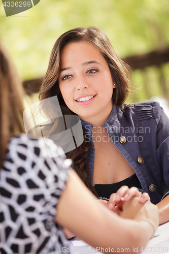 Image of Two Mixed Race Girlfriends Having A Conversation At An Outoor Pa