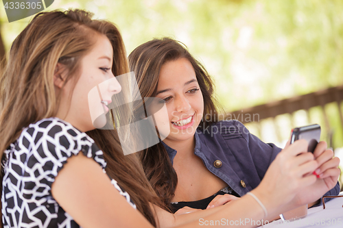 Image of Expressive Young Adult Girlfriends Using Their Smart Cell Phone 