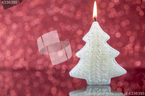 Image of Christmas tree candle light with reflection on red blurred bokeh