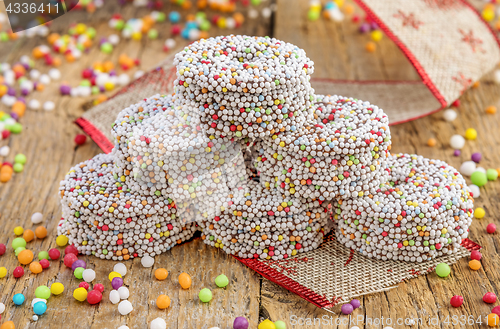 Image of Colored chocolate rings with Christmas decoration on wood