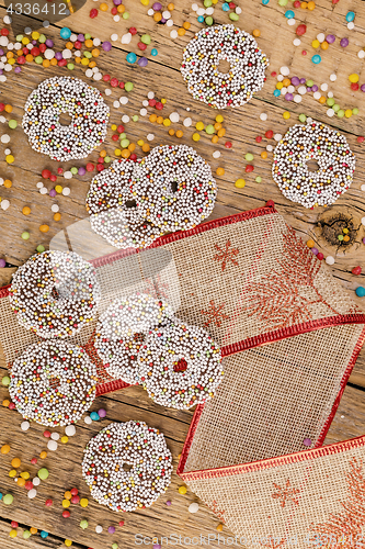 Image of Colored chocolate rings with Christmas decoration on wood