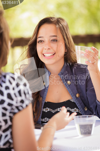 Image of Expressive Young Adult Woman Having Drinks and Talking with Her 