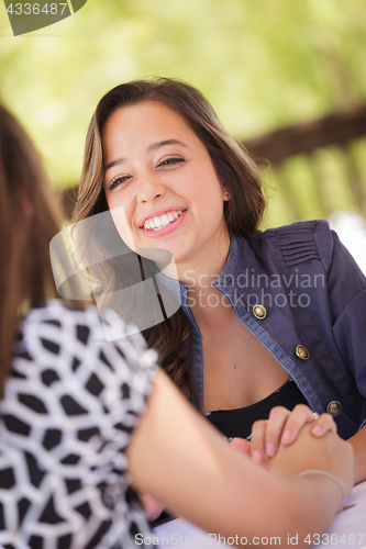Image of Two Mixed Race Girlfriends Having A Conversation At An Outoor Pa
