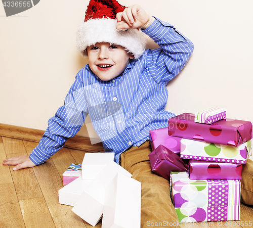 Image of little cute boy with Christmas gifts at home. close up emotional